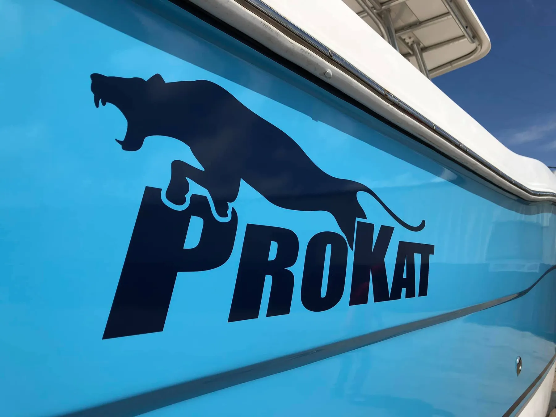 Cut vinyl logo decal on a light blue boat hull