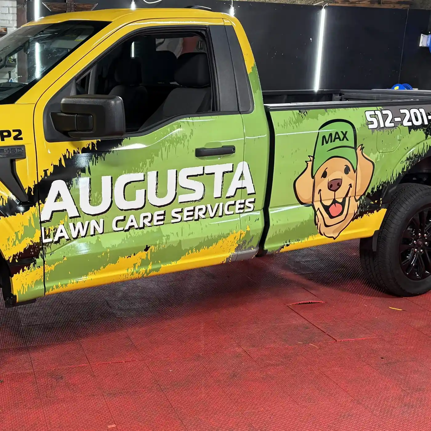 Augusta Lawn Care Services pickup wrapped in green and yellow with a dog mascot